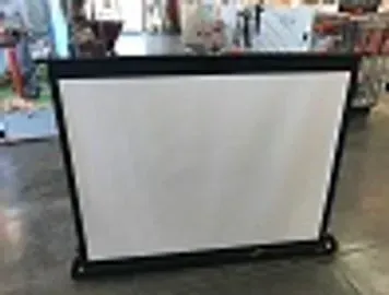 Black framed, white portable projector screen on a concrete floor.