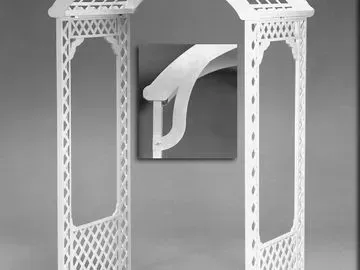 White lattice archway with decorative top and a sculptural white form against a gray background.