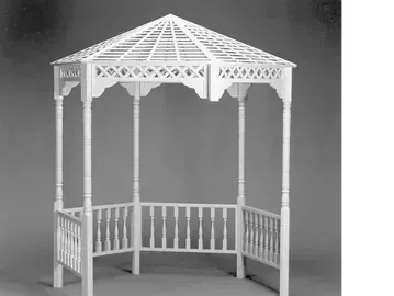 White gazebo with lattice roof and railing, standing outdoors.