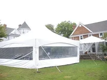 White event tent in backyard, with clear window panels, houses in the background.