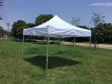 White pop-up canopy tent in a grassy field on a sunny day.