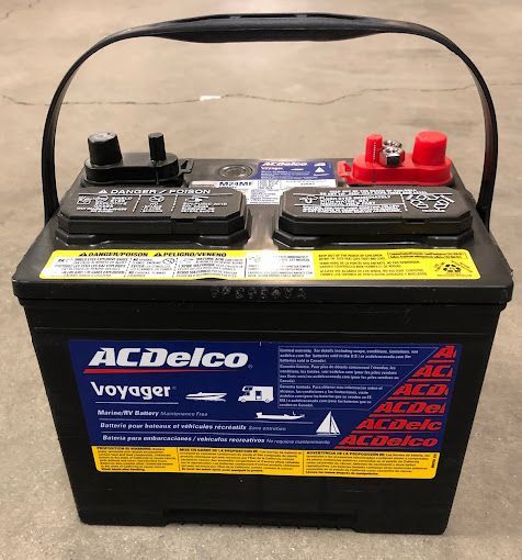 An acdelco voyager battery is sitting on a concrete floor.