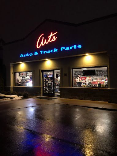 The outside of a auto and truck parts store at night
