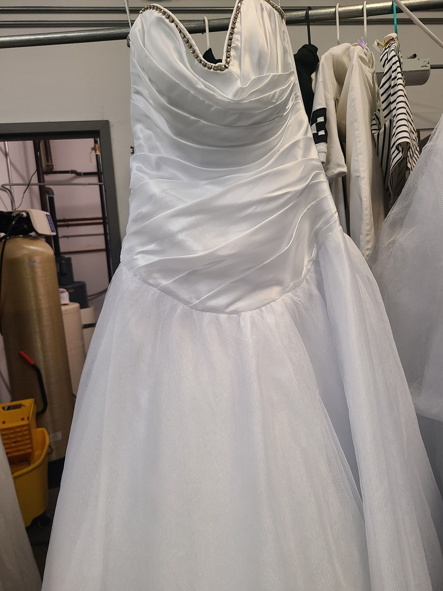 White strapless wedding dress hanging on a rack in a bridal shop