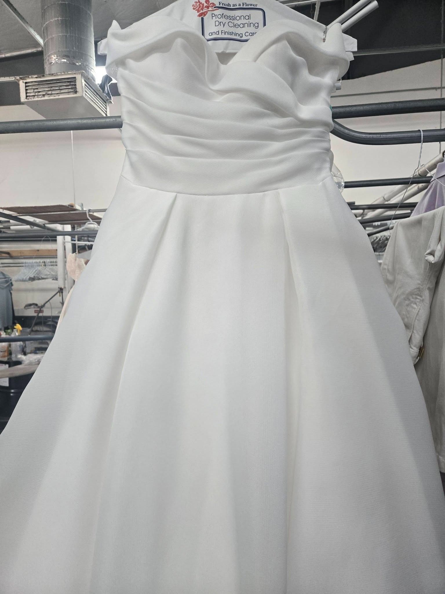 White strapless wedding dress hanging on a rack in a bridal shop