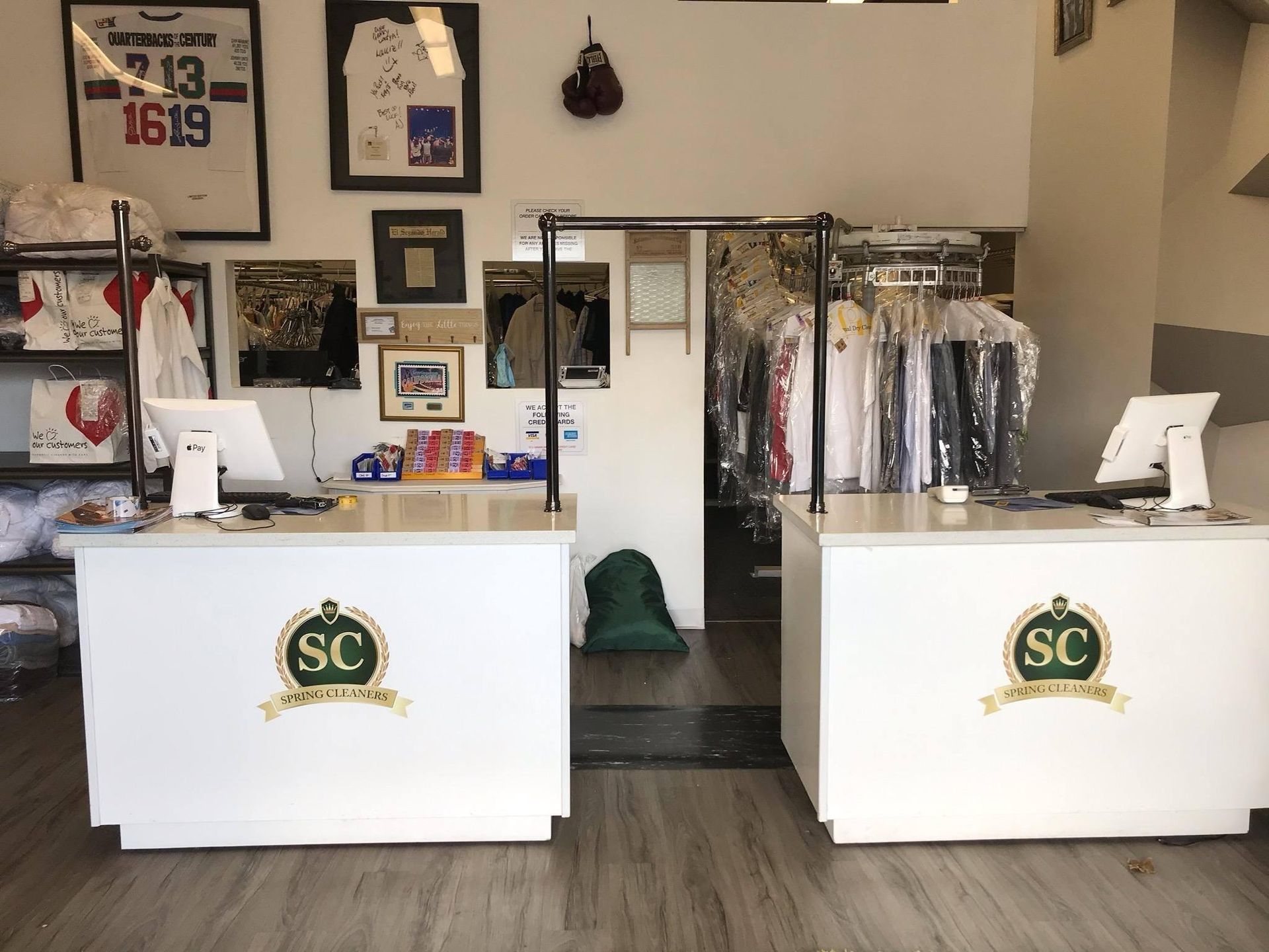 Retail shop interior with two white SC-branded counters and clothing racks in the background