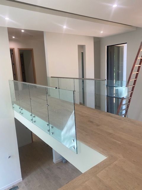 A staircase with a glass railing and a wooden floor