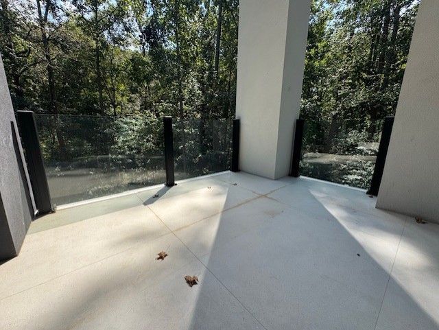 Balcony with glass railing overlooking a forest