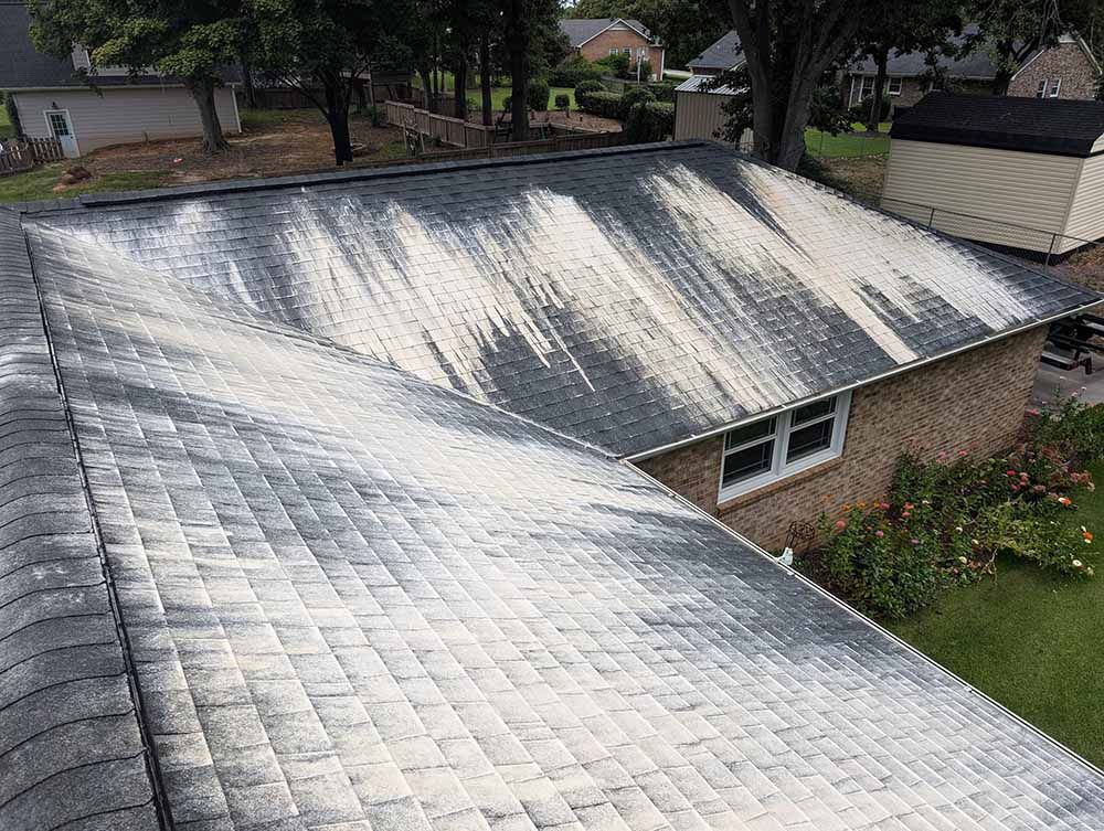 A roof of a house with a lot of white stains on it.