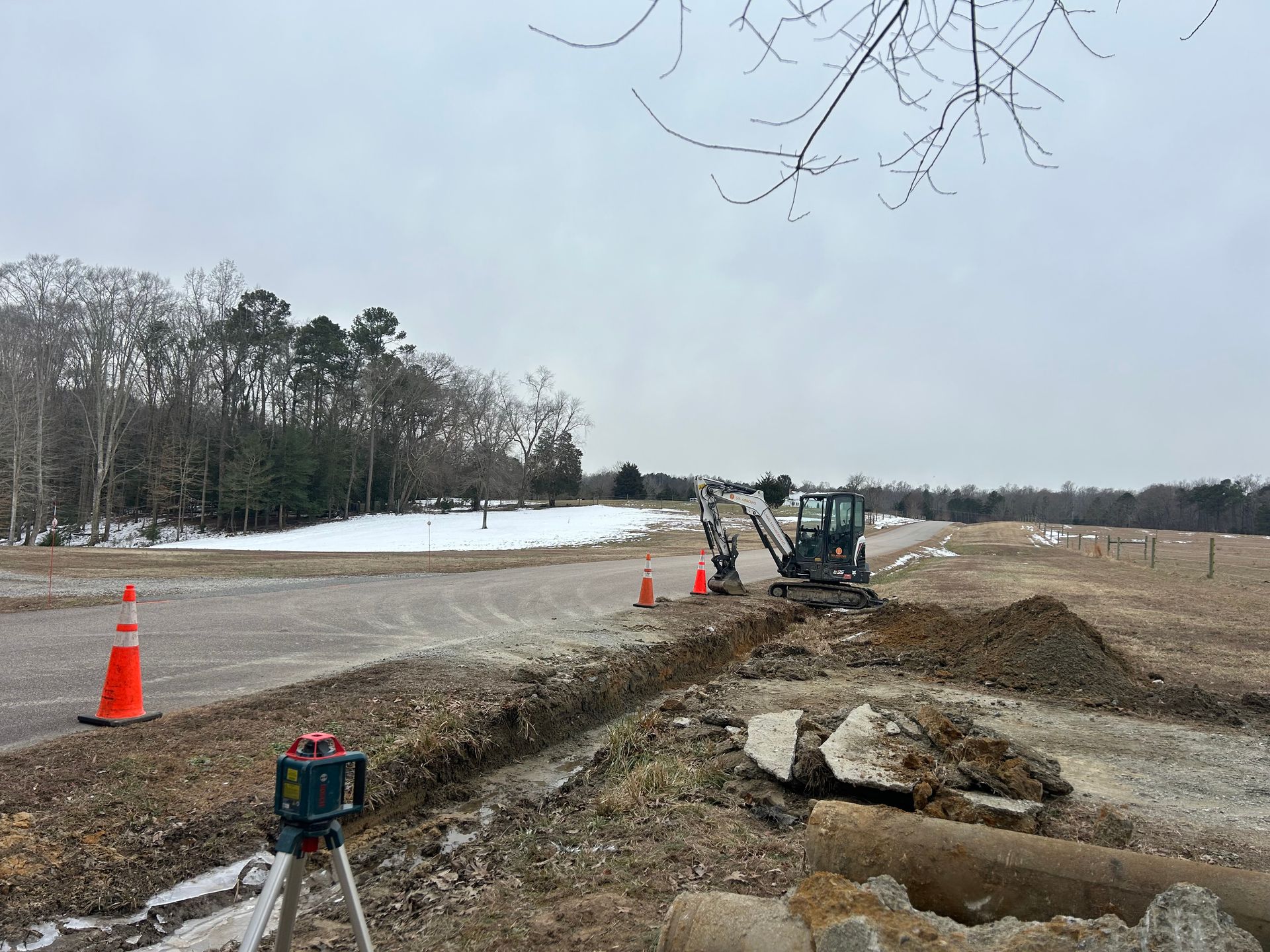 A construction site with a lot of dirt and trees in the background.
