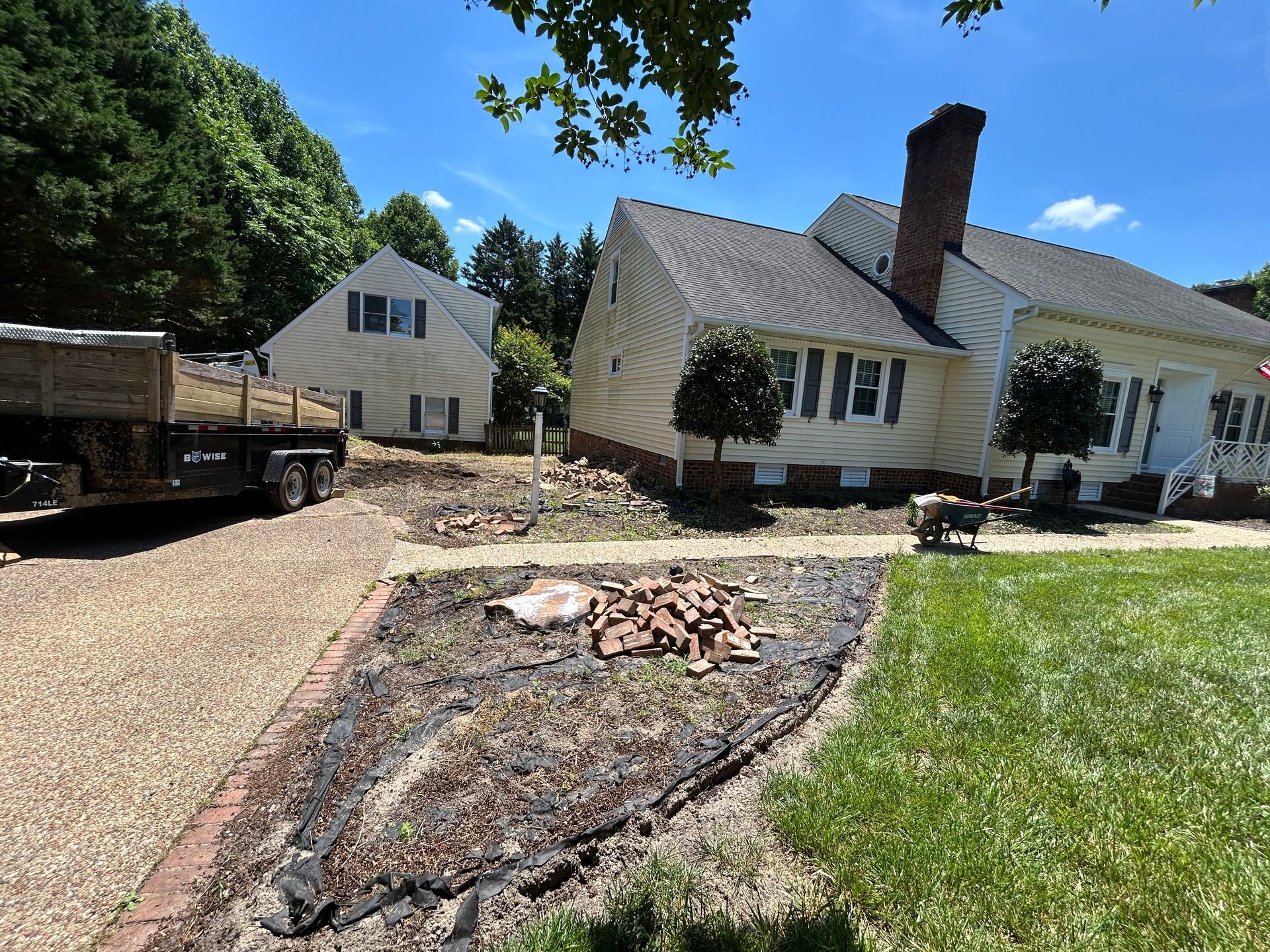 A truck is parked in front of a house on a sunny day.