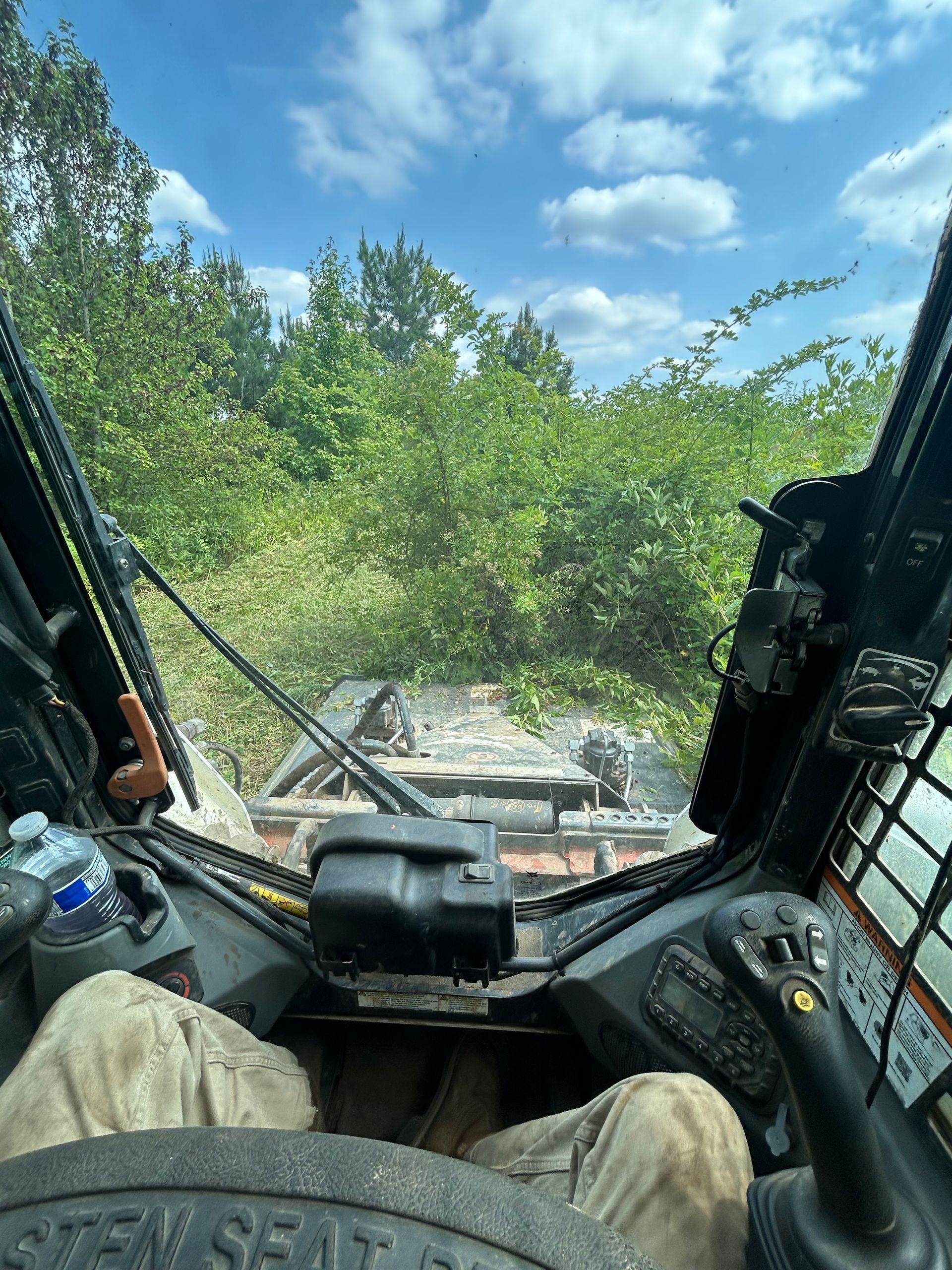 A person is sitting in the driver 's seat of a bulldozer.