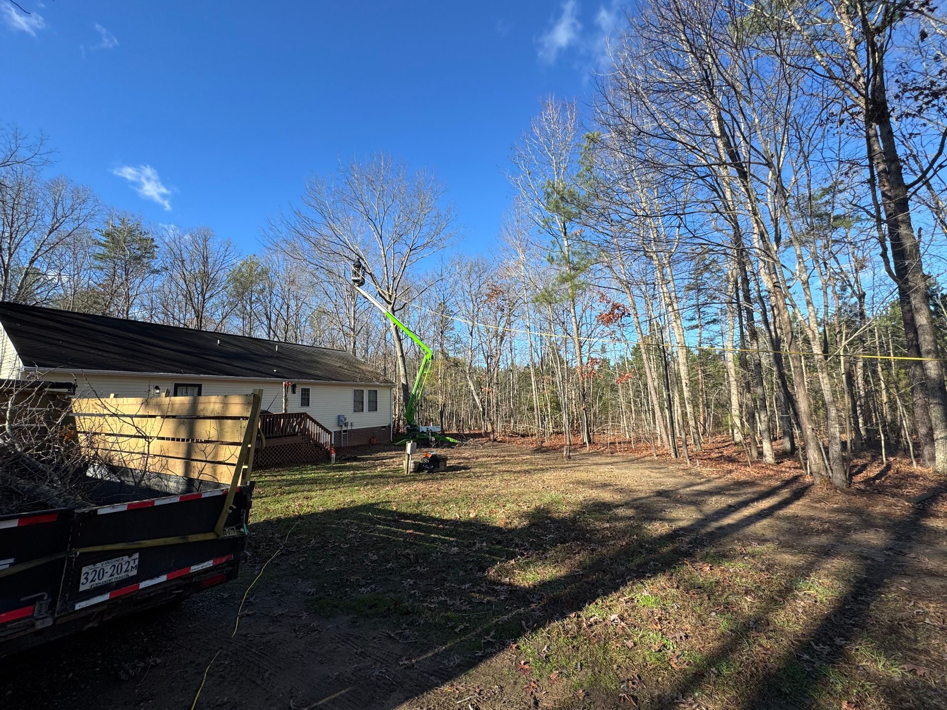 A house is surrounded by trees and a truck is parked in front of it.