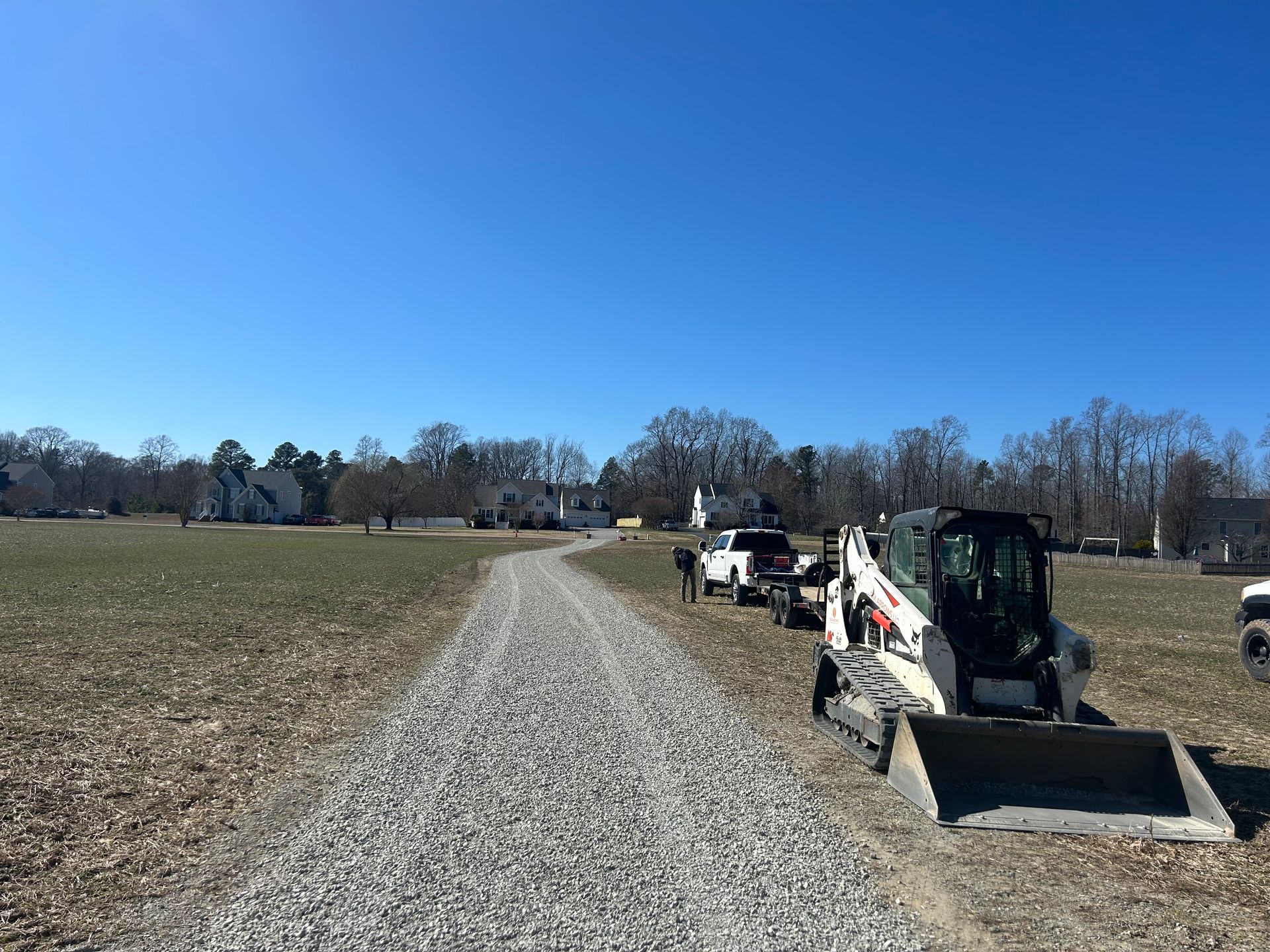 A bulldozer is parked on the side of a gravel road.