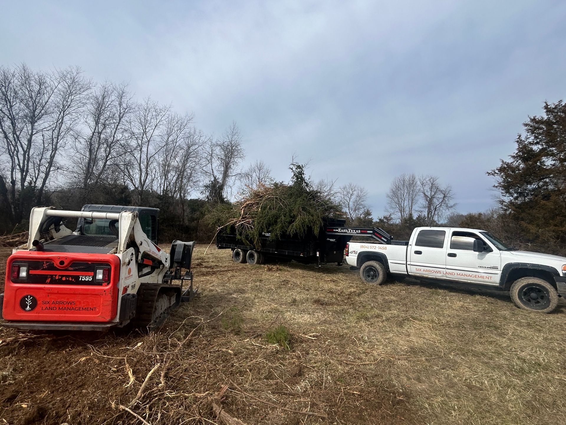A bulldozer and a truck are parked in a field.