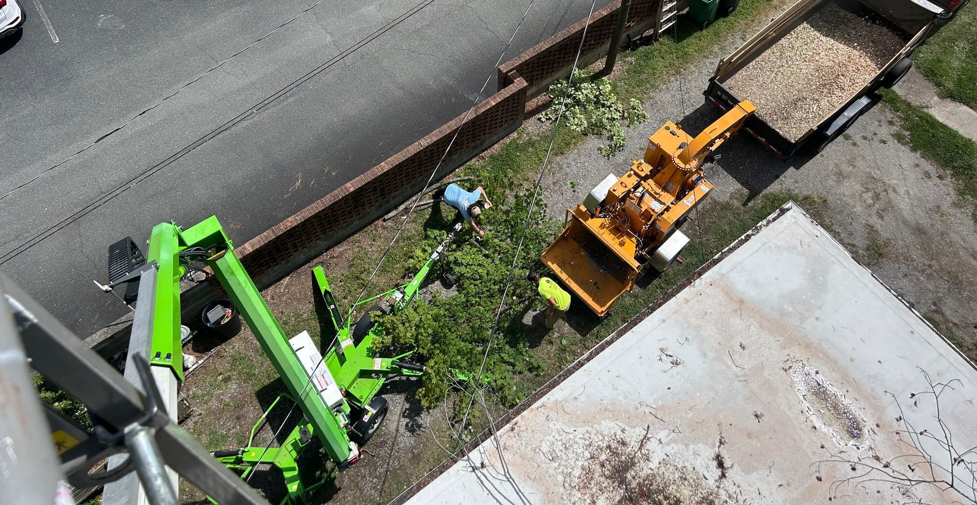 An aerial view of a construction site with a green crane and a yellow bulldozer.