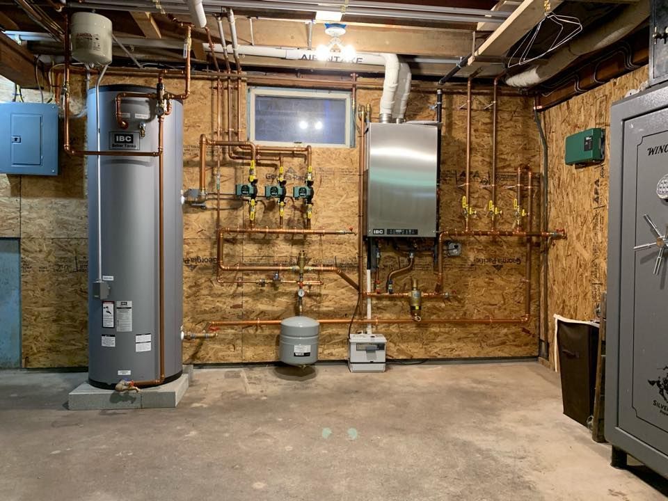 A basement with a water heater and a boiler.