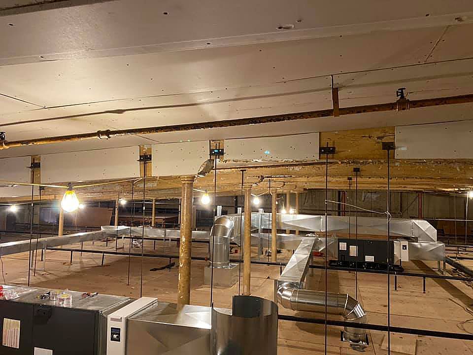 A large room with a lot of pipes hanging from the ceiling.