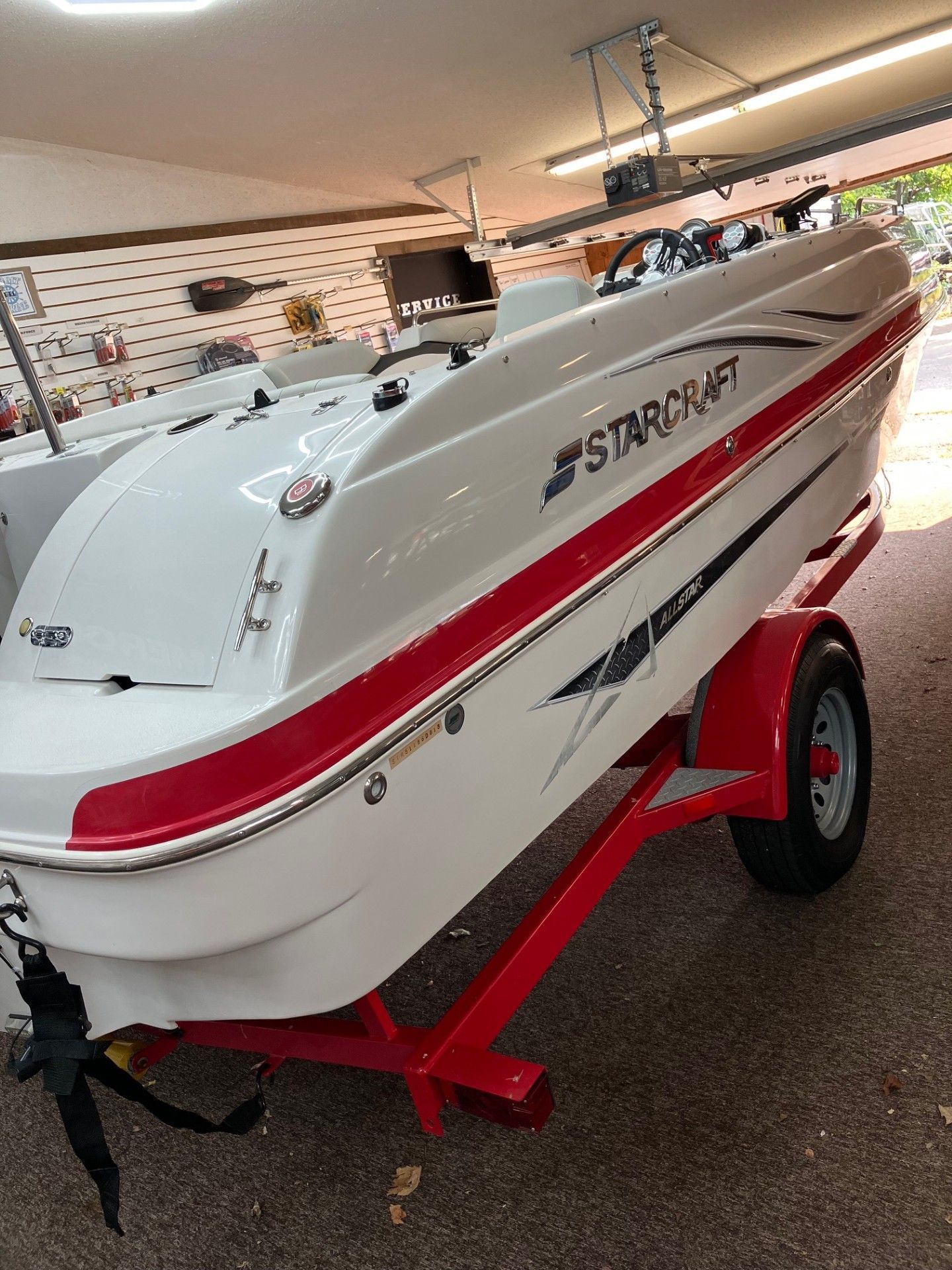 White and red speedboat on a red trailer in an indoor showroom