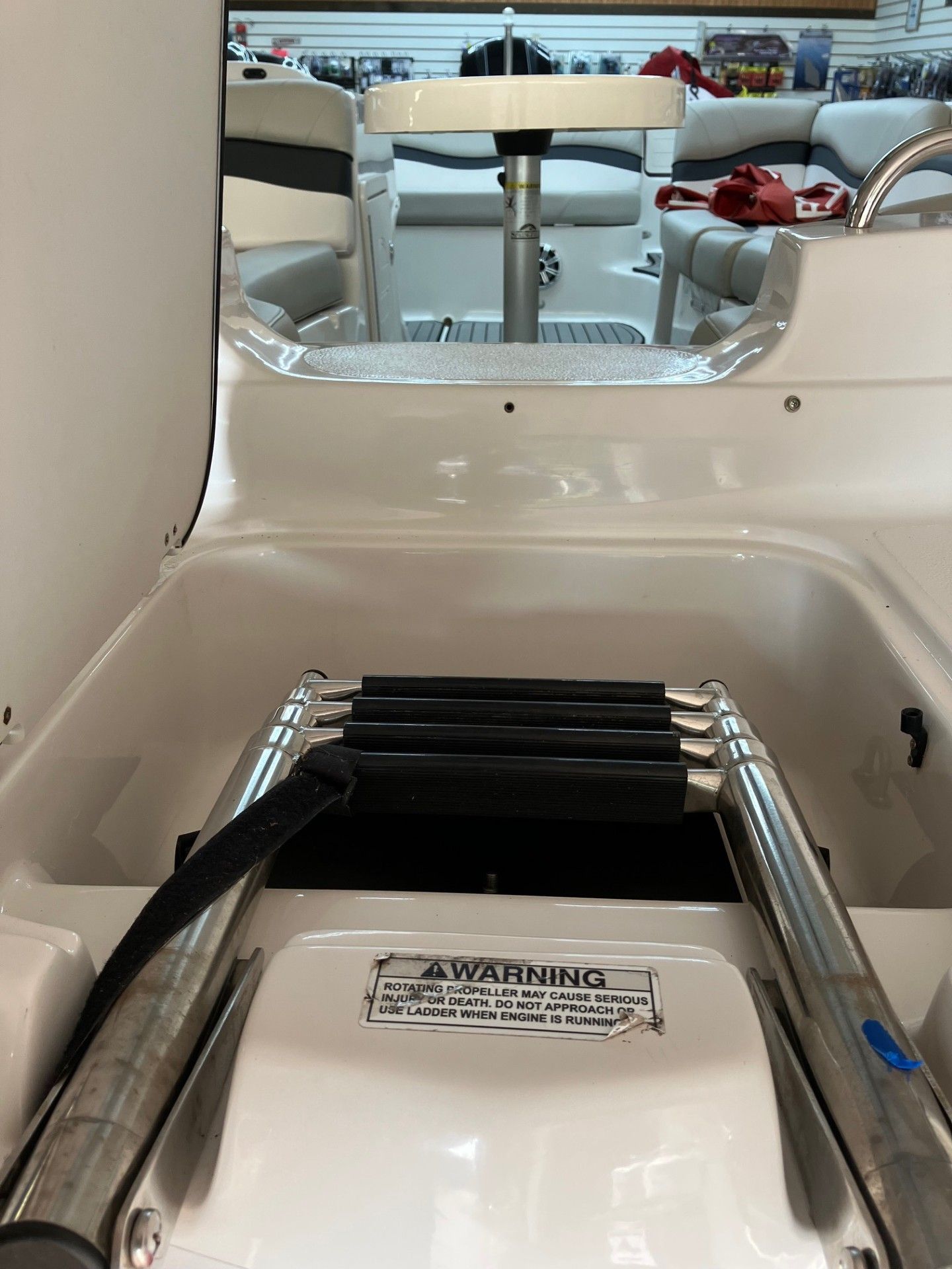 White arcade ride seat with black footrests inside a mirrored, padded interior.