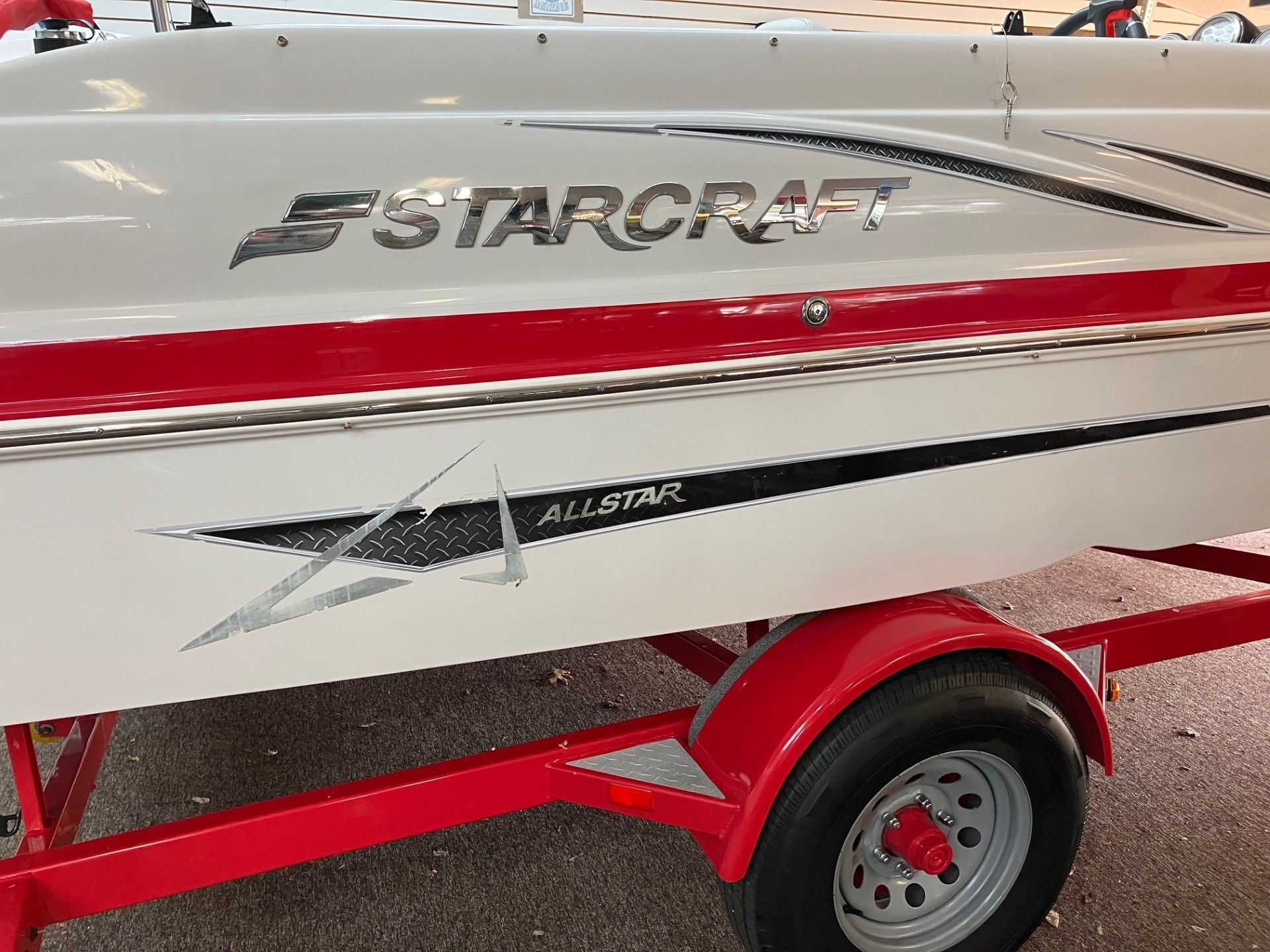 White Starcraft boat with red stripe on a red trailer
