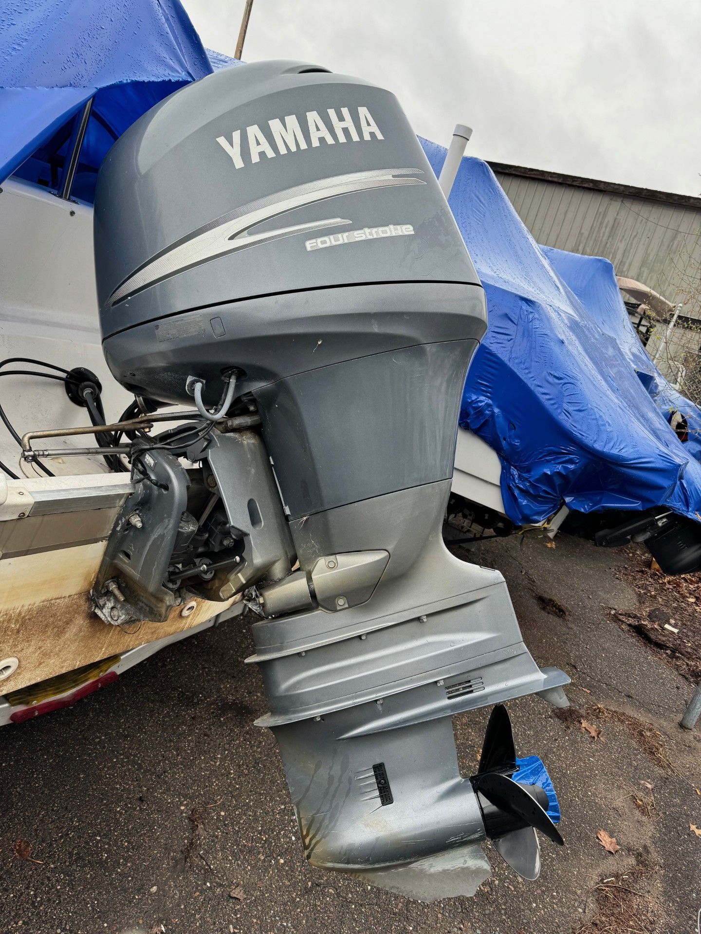 A yamaha outboard motor is sitting on the ground next to a boat.