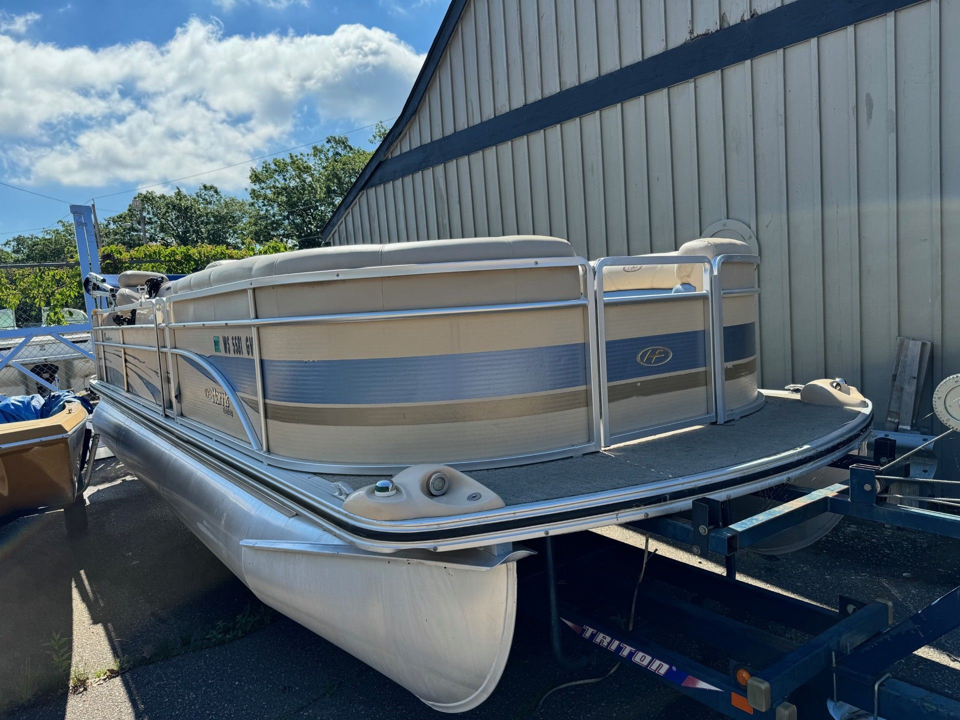 A pontoon boat is parked in front of a building.