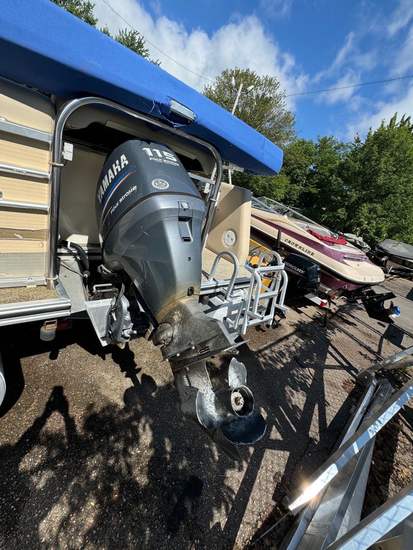 A boat with a yamaha outboard motor is parked in a lot.