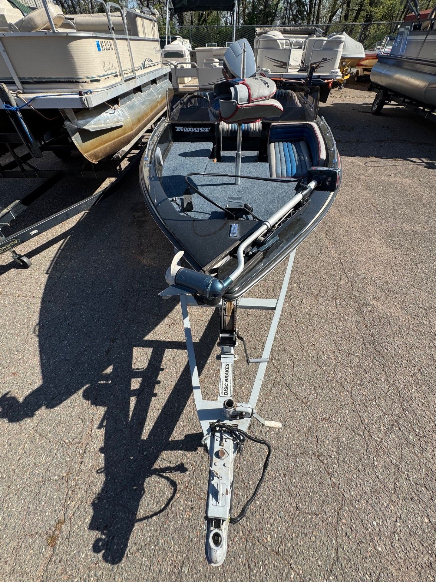 A boat is sitting on a trailer in a parking lot.