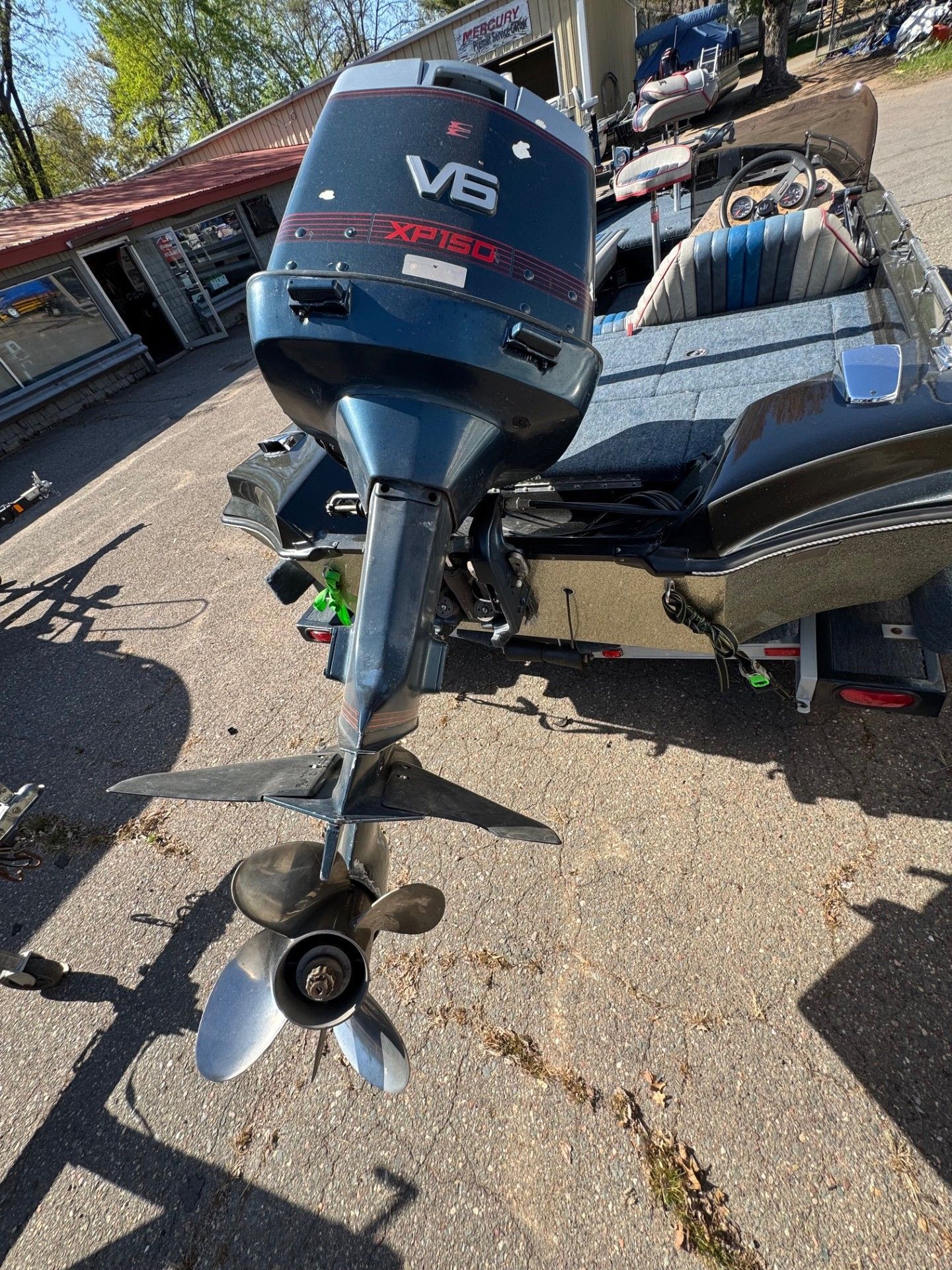 A boat with a motor attached to it is parked on the side of the road.