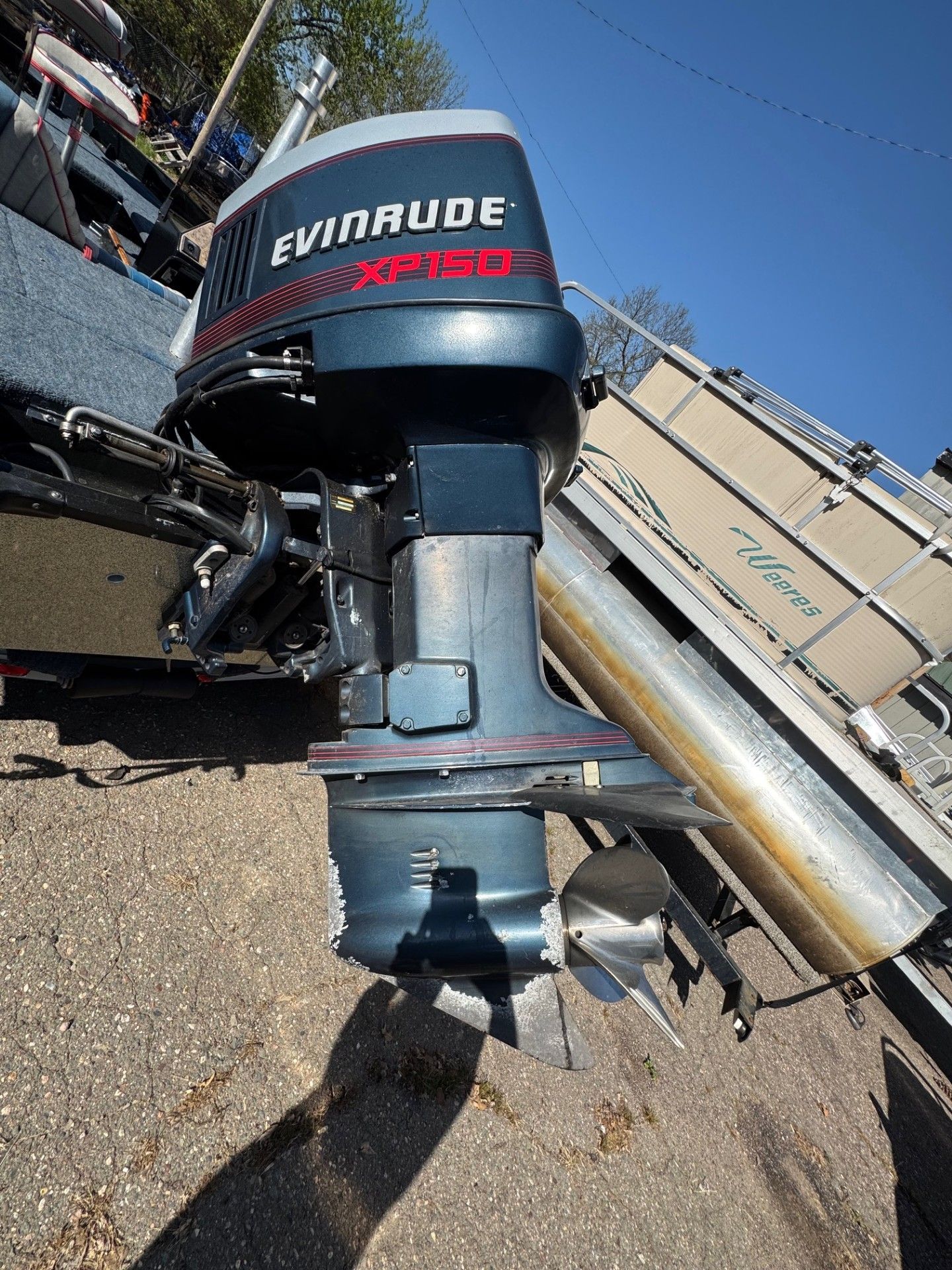 An evinrude outboard motor is sitting on the ground next to a boat.