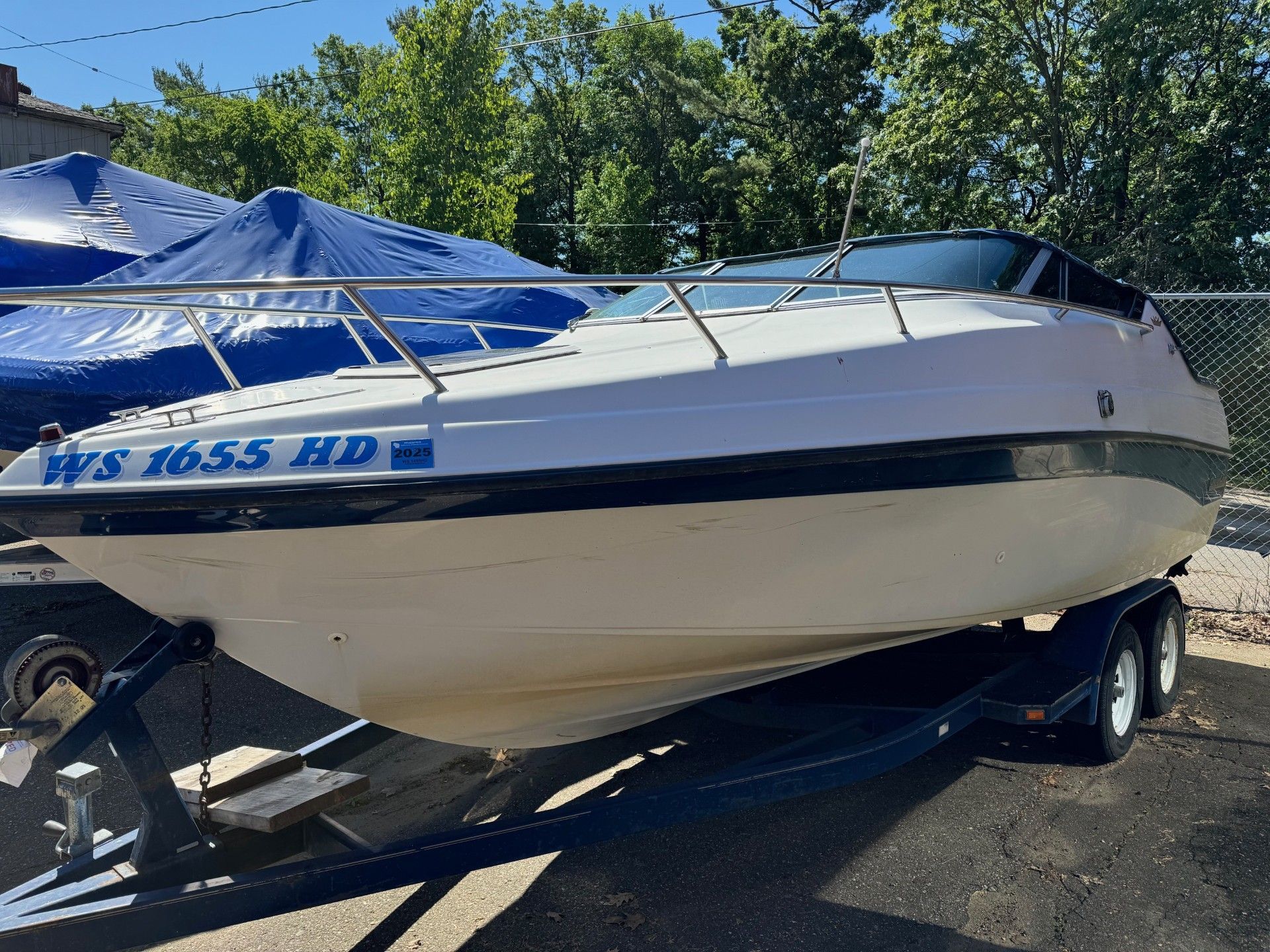 A white boat with the text WS 1655 HD is on a trailer