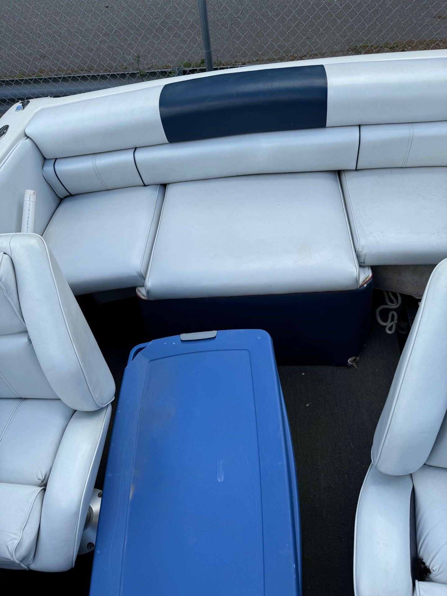 A boat with white leather seats and a blue cooler