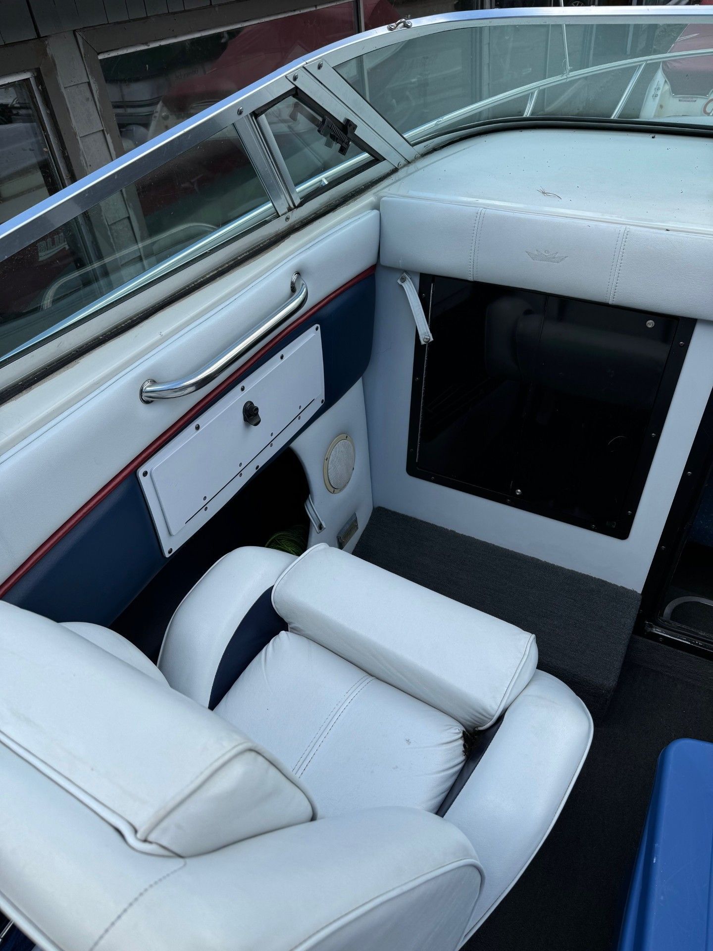 The inside of a blue and white boat with a white seat