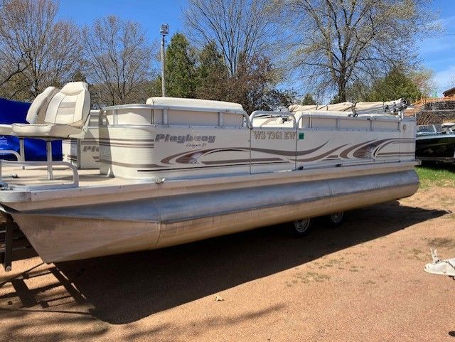 A pontoon boat is parked on the side of the road.