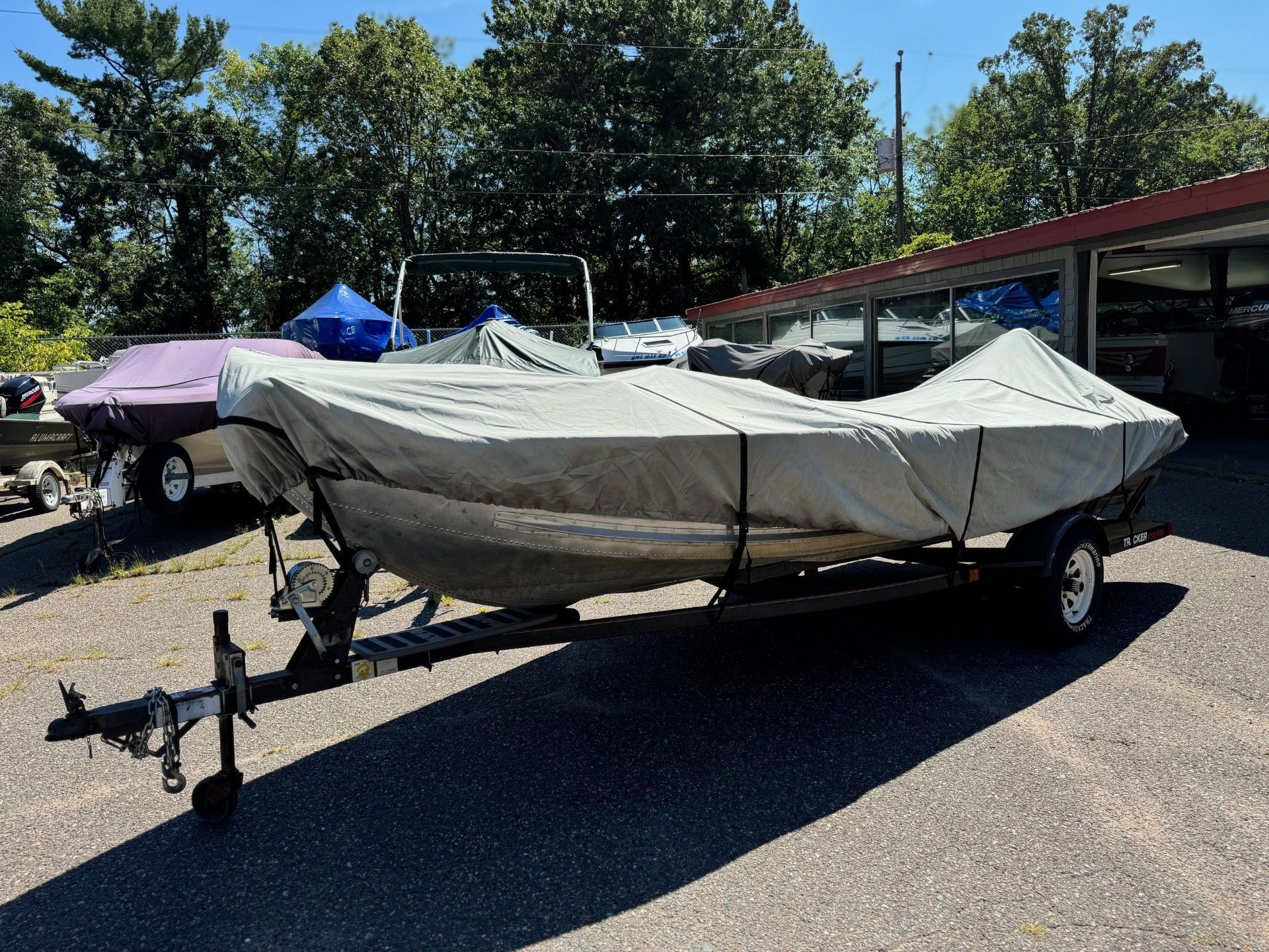 A boat with a cover on it is parked in a parking lot.