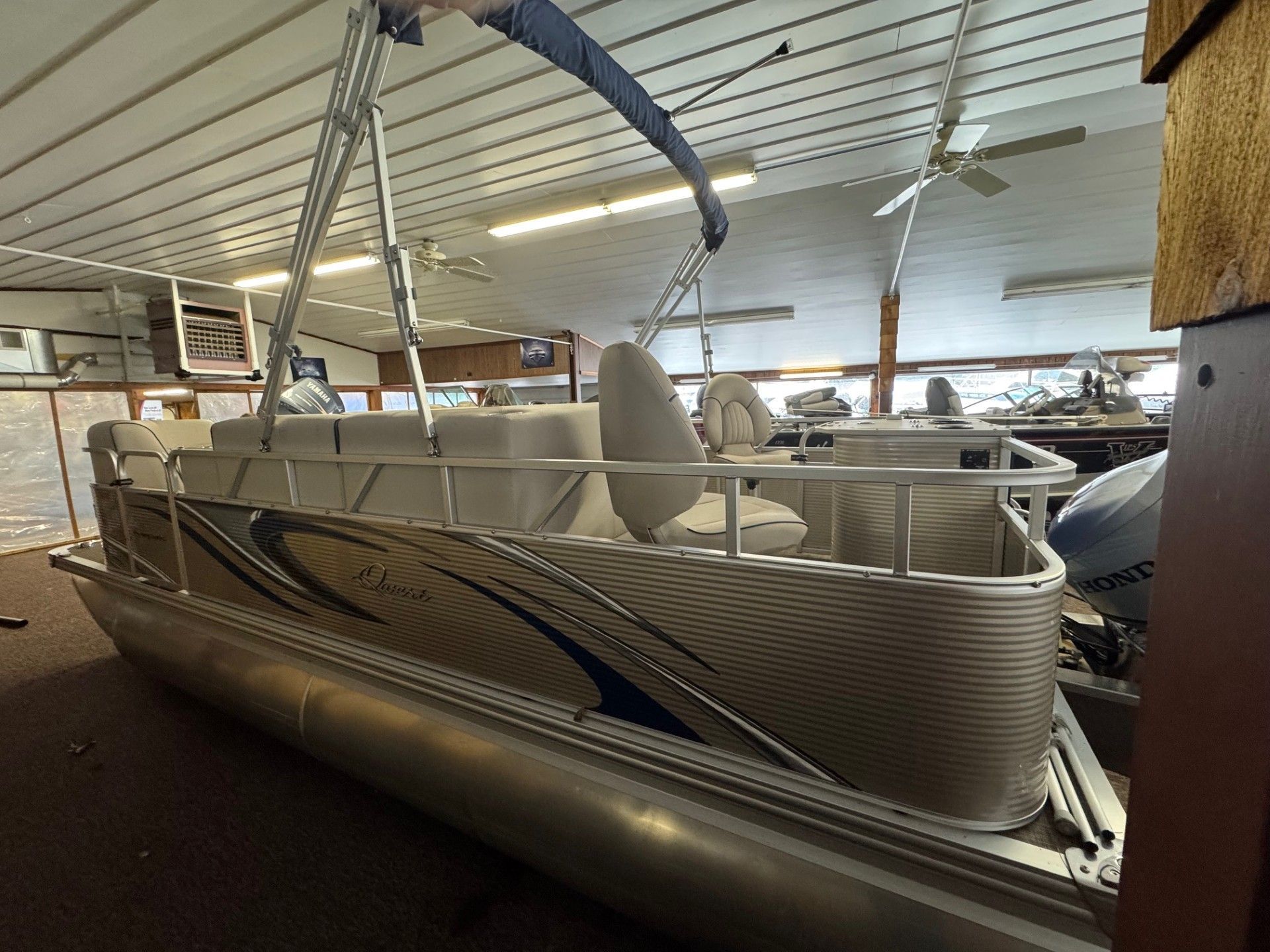 A pontoon boat is sitting in a showroom.