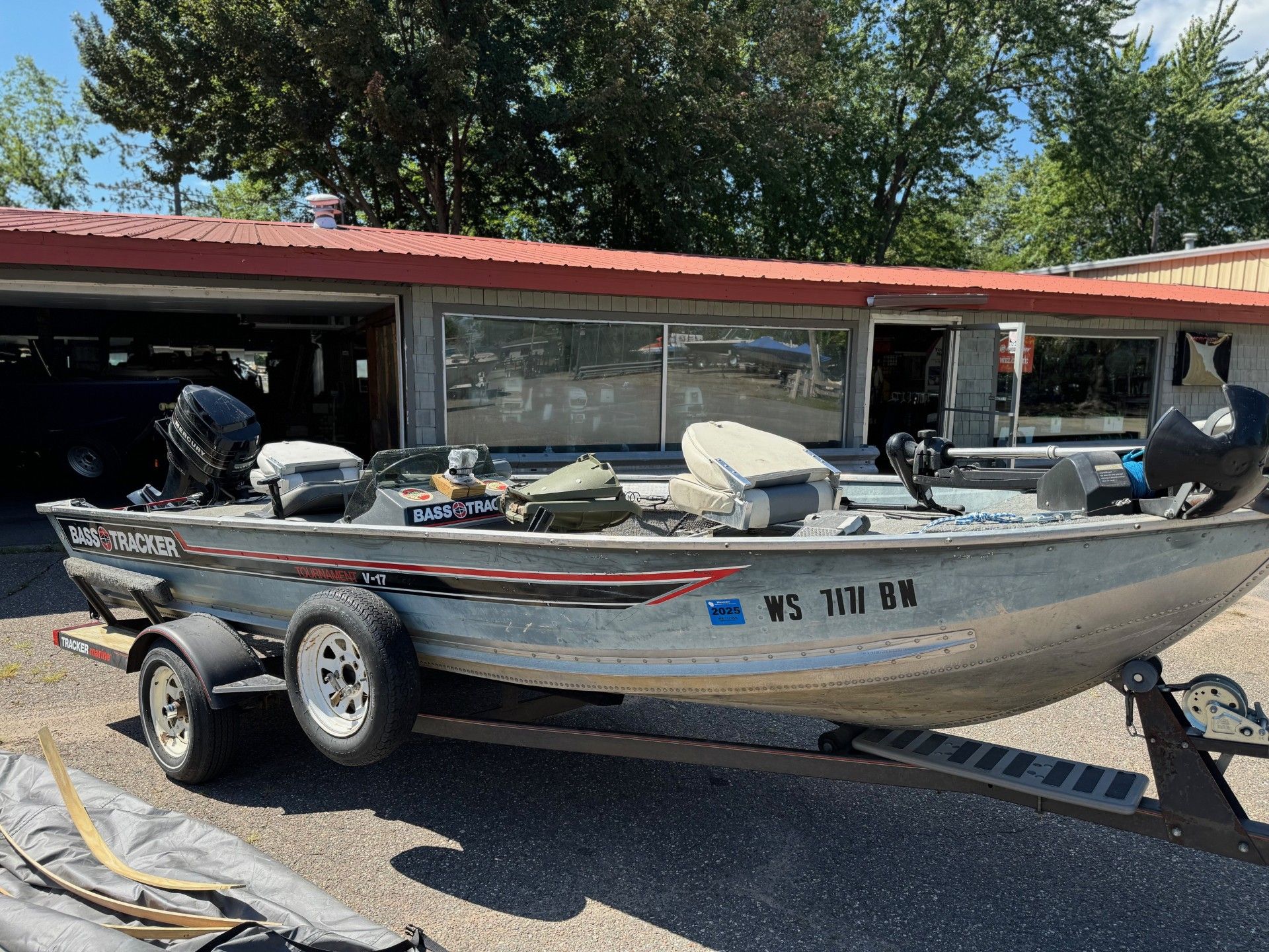 A fishing boat is parked in front of a garage.