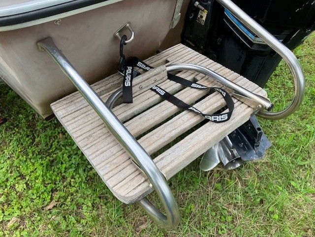 A wooden ladder is attached to the back of a boat.