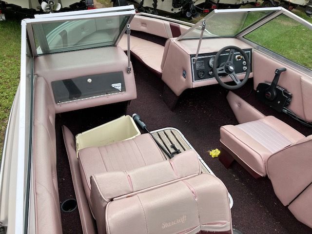 A boat with pink seats and a steering wheel