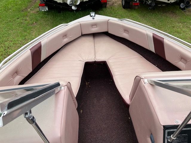 The inside of a boat with pink and brown seats