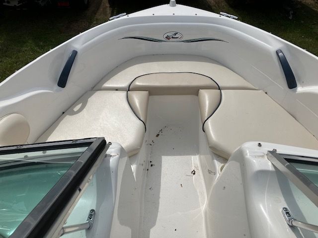 The front of a white boat with a cushioned seat