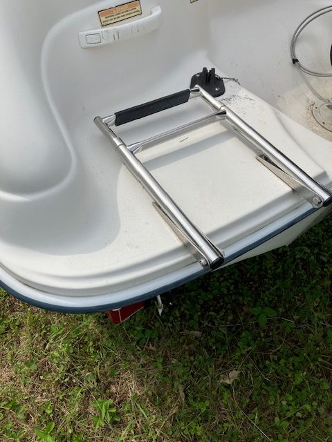 A boat with a ladder attached to the back of it