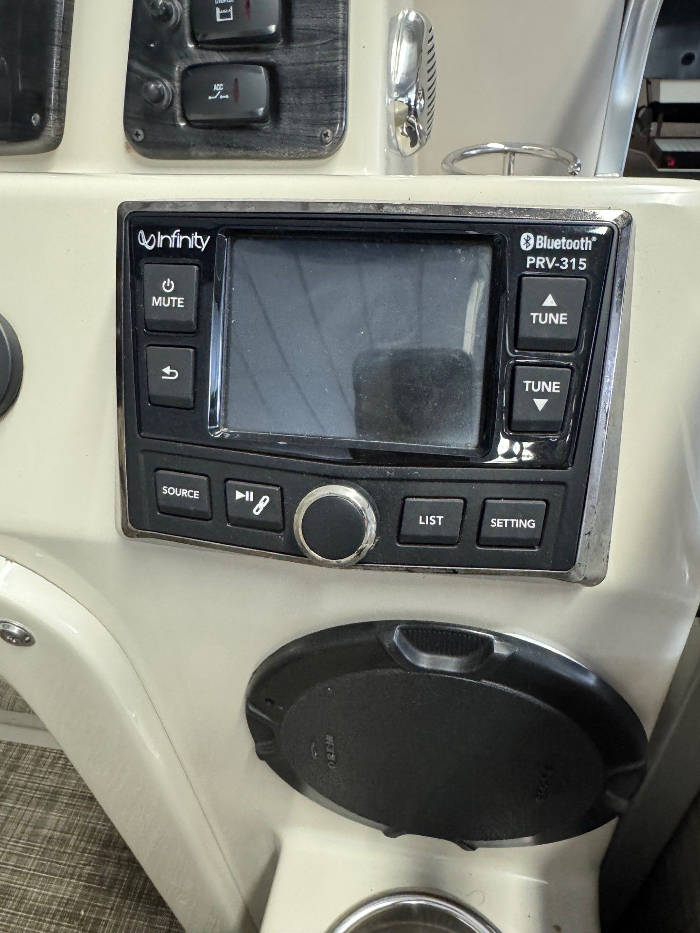 A boat dashboard with a infinity radio on it