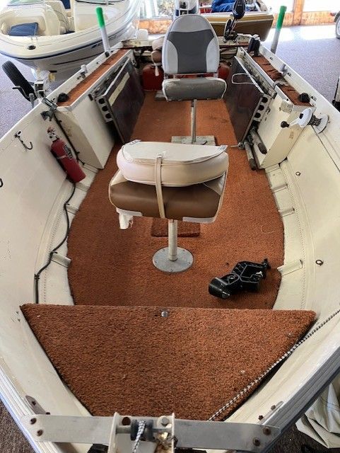 The inside of a boat with a seat and a fire extinguisher