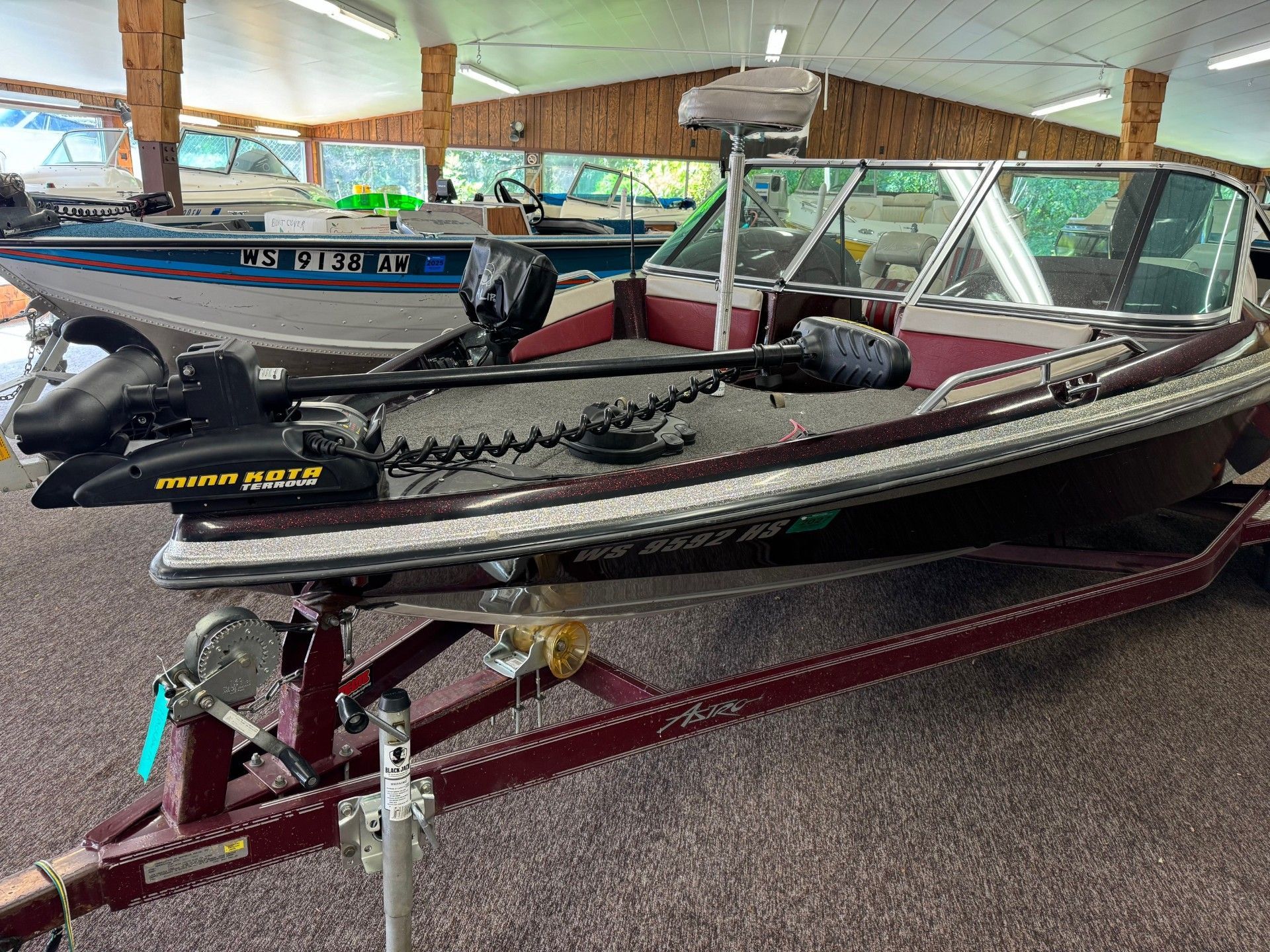 A fishing boat is parked on a trailer in a showroom