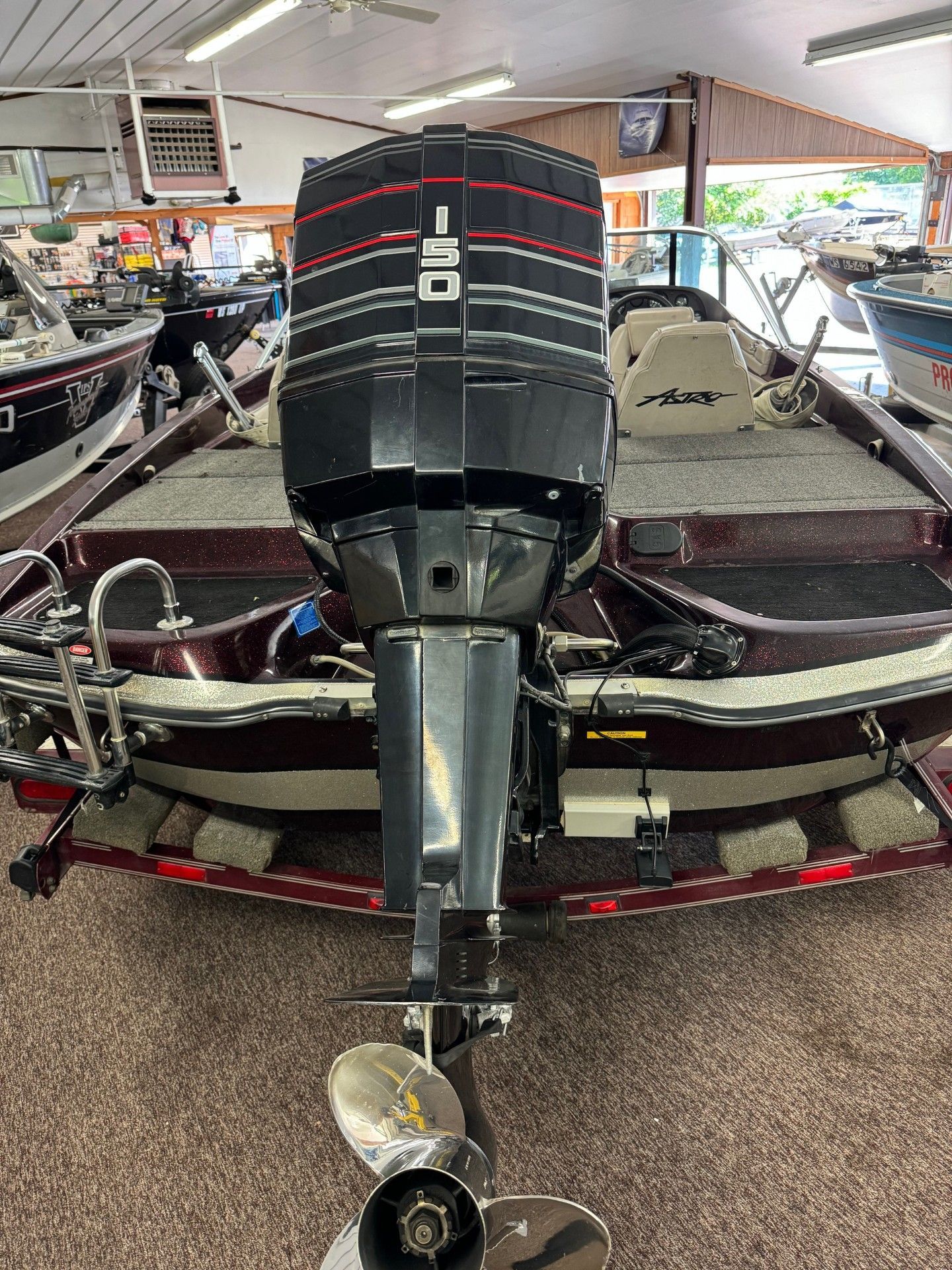 A boat with a motor attached to it is sitting in a showroom