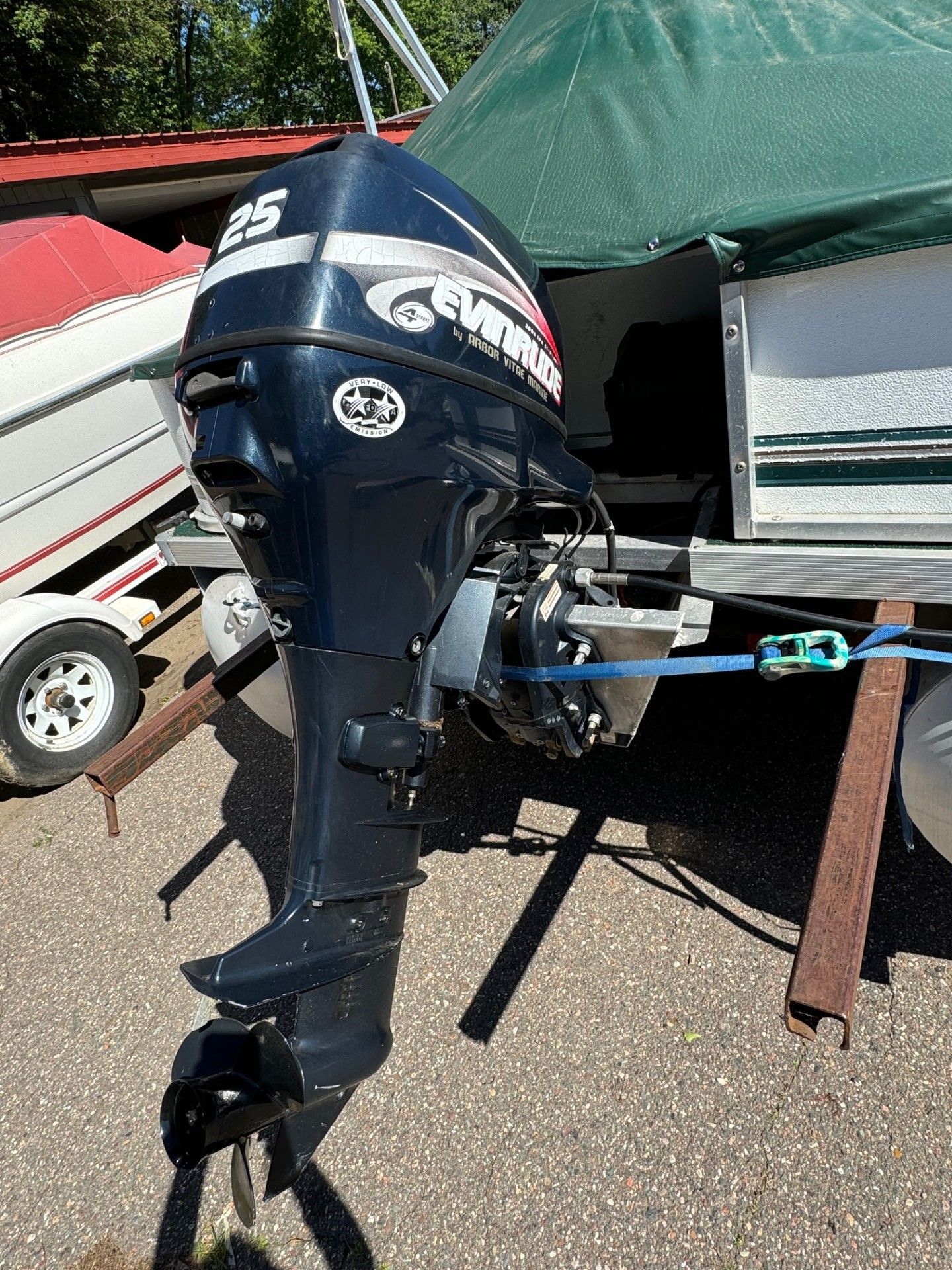 A boat engine is sitting on the ground next to a boat