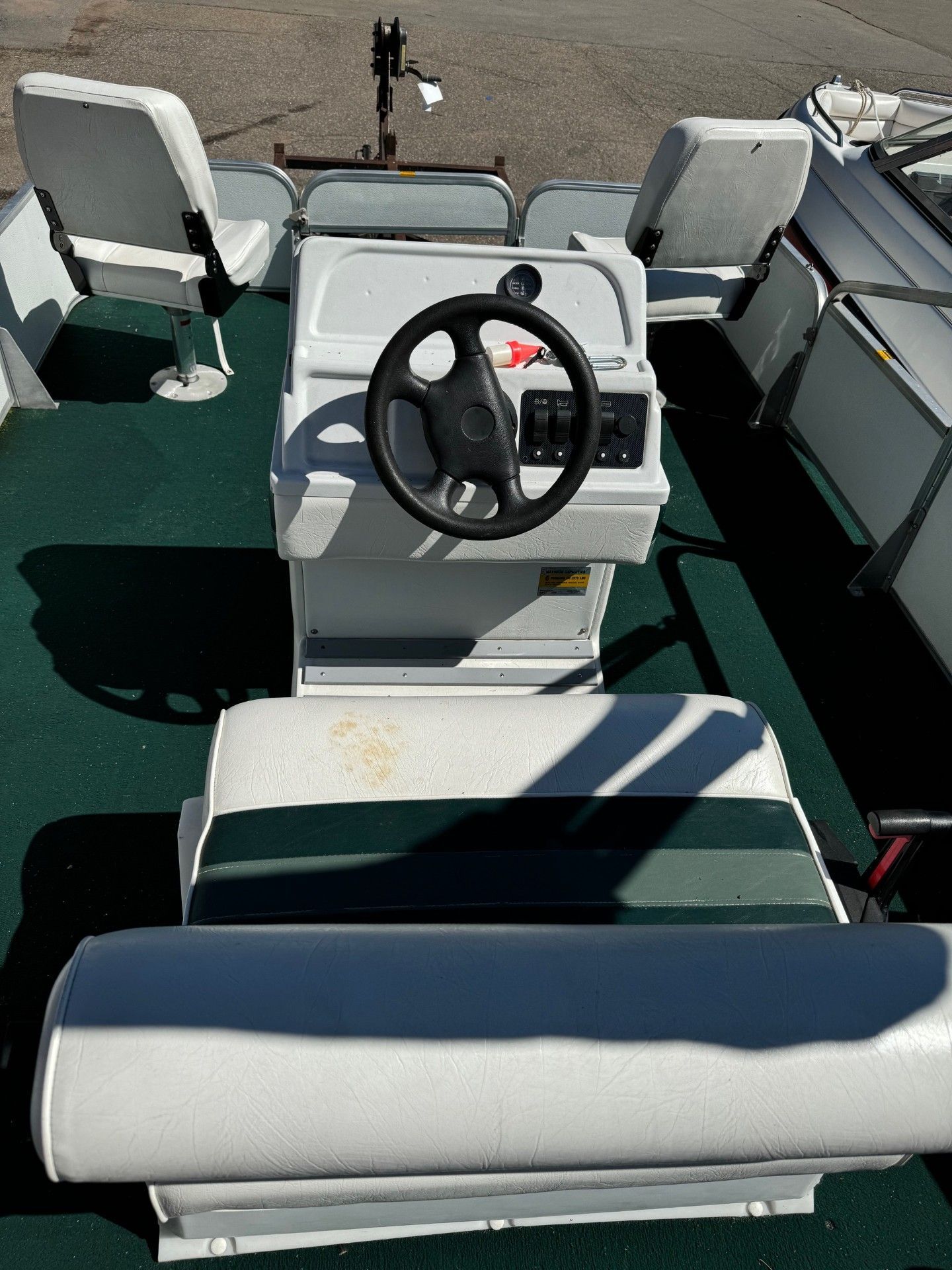 The inside of a boat with a steering wheel and seats