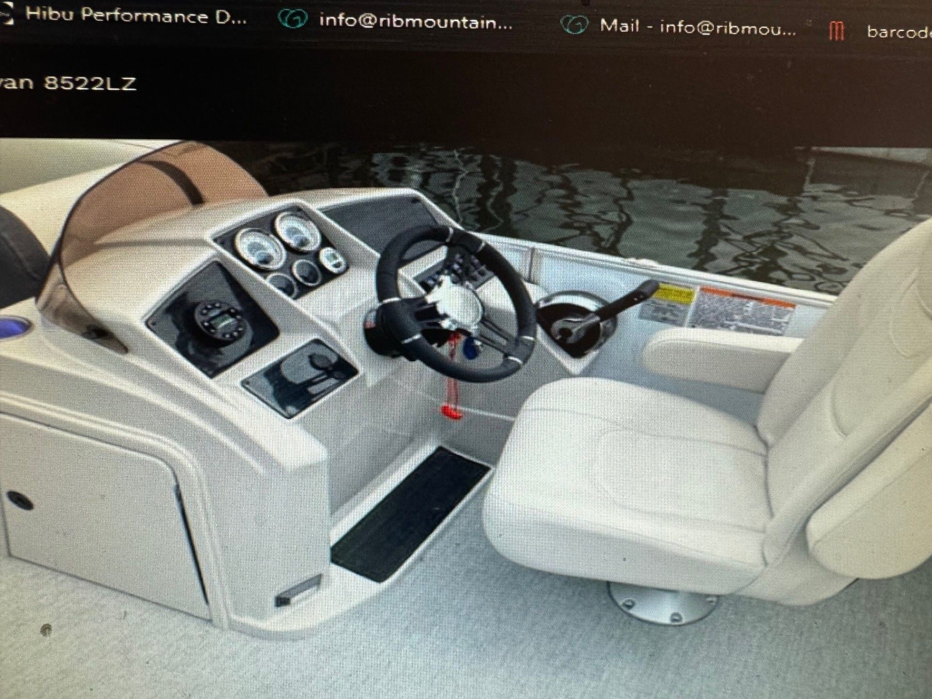 The inside of a boat with a steering wheel and a seat